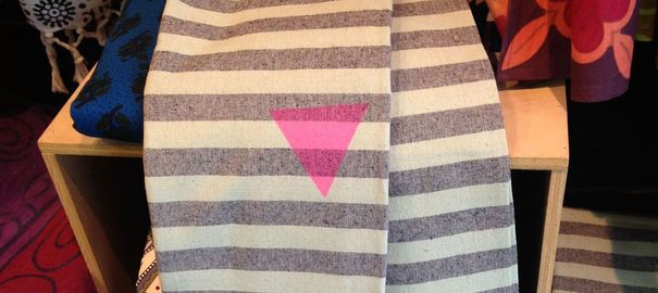 Une étole "Urban Outfitters" avec le triangle rose évoquant l'uniforme des déportés homosexuels