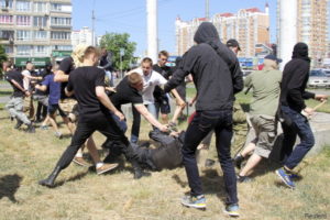 Anti-gay protesters attack a policeman during a march organized by LGBT community in Kiev